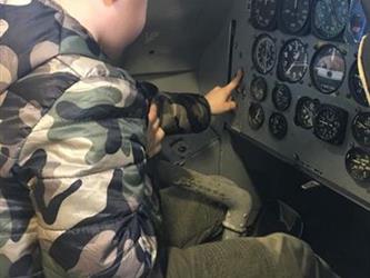 boy sitting in an airplane model in a museum