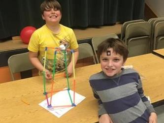 two boys smiling with their science project