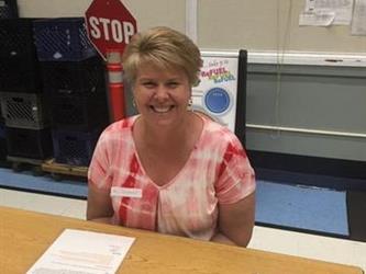 teacher sitting at a desk with paperwork