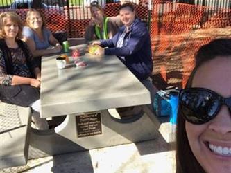 teachers having lunch outside on a bench