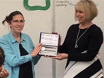 teachers holding an award in a classroom