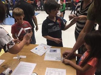 students gathered around a table doing an activity