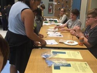 students at tables doing activities