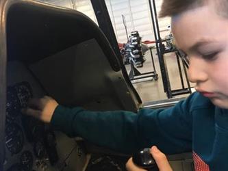 boy sitting in an airplane model in a museum