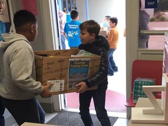 two students carrying a box