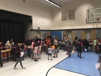 students and parents walking around tables at the science fair