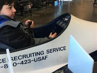 boy sitting in an airplane model in a museum