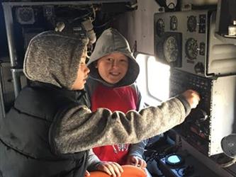 boys in an airplane model in a museum