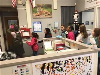 students in line walking through an office