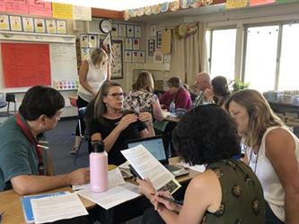 room of teachers having a meeting in groups