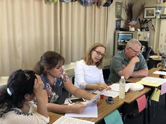 teachers sitting at desks in a meeting