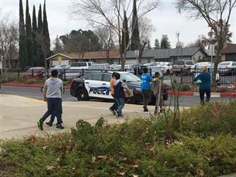 students walking outside carrying boxes