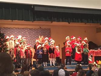 students on stage for a holiday performance in the cafeteria