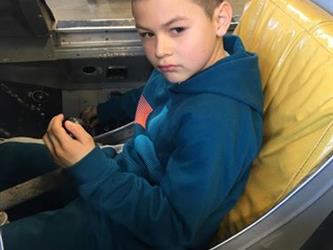 boy sitting in an airplane model in a museum