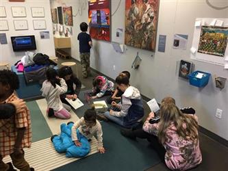 students working on the floor at an art exhibit