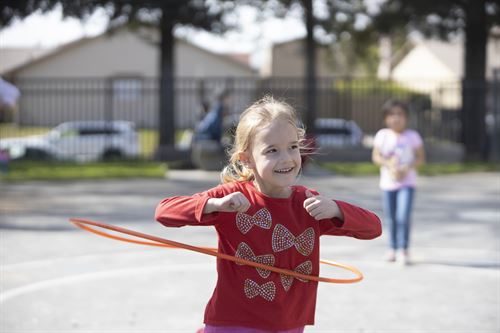 girl playing with a hula hoop outside
